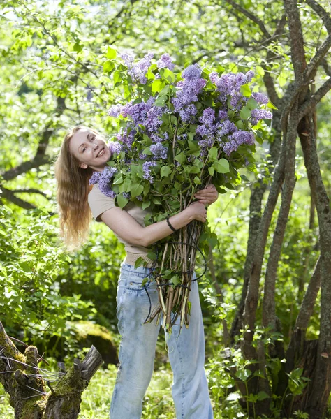 ライラックの大きな花束を持つ公園で幸せな若い女 — ストック写真