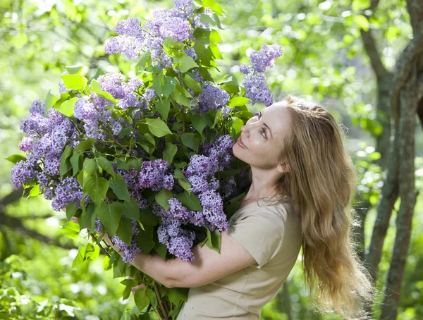 Heureuse jeune femme dans le parc avec un gros bouquet d'un lilas — Photo