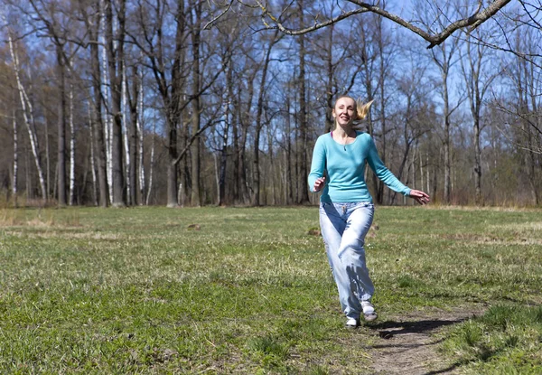 Frau läuft im Frühlingswald auf die Gleise — Stockfoto