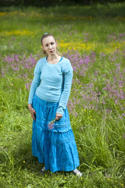 Η όμορφη νεαρή γυναίκα σε ένα μπλε φόρεμα στο πεδίο — Φωτογραφία Αρχείου
