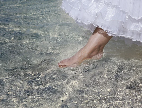 El pie de la novia toca el agua en el mar —  Fotos de Stock