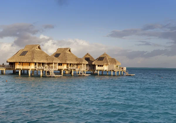 Typiskt polynesiskt landskap - små hus på vatten. — Stockfoto