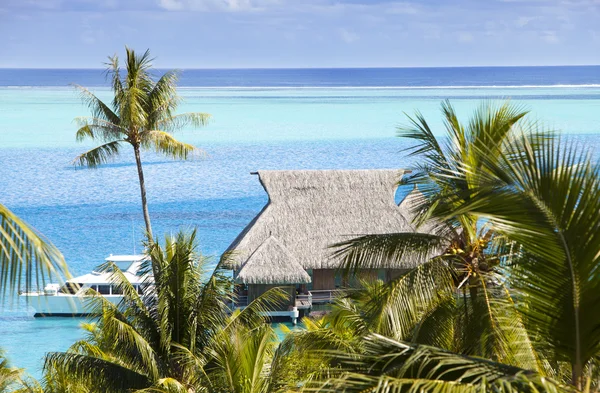 Blaue Lagune der Insel Bora Bora, Polynesien. Blick aus der Höhe auf Palmen, traditionelle Hütten über Wasser und Meer — Stockfoto