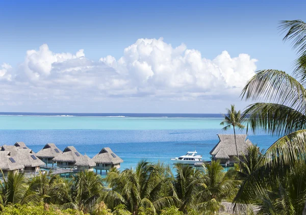 Blauwe lagune van het eiland van Bora Bora, Polynesië. Een weergave van hoogte op palmbomen, traditionele lodges over water en de zee — Stockfoto