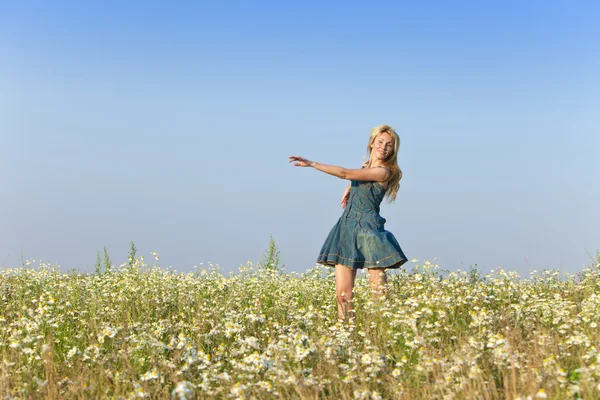 La joven feliz en el campo de las manzanillas —  Fotos de Stock