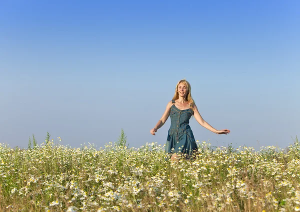Den glada unga kvinnan i fältet för camomiles — Stockfoto