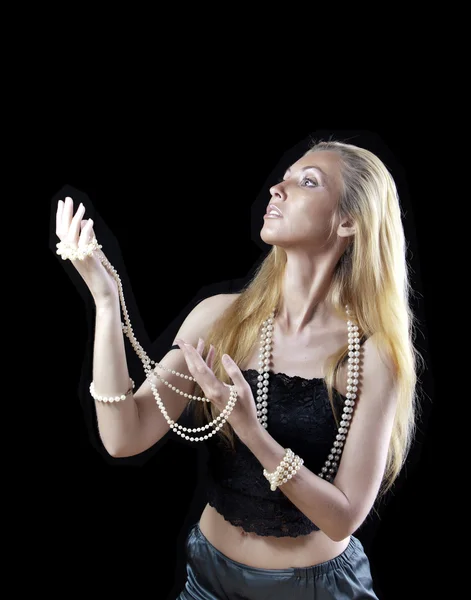 The beautiful blonde woman with long hair, with a pearl beads, looks upward with a smile and  shielded with hands — Stock Photo, Image