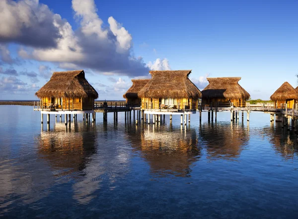 Casas sobre el agua de mar tranquila transparente en una puesta de sol —  Fotos de Stock