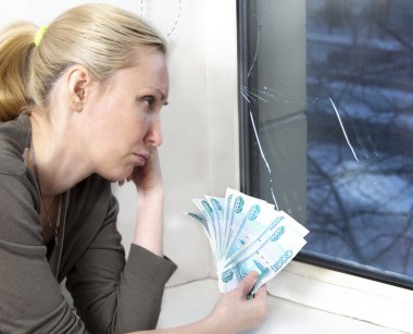 The sad young woman counts money for window repair with the burst, broken glass clipart