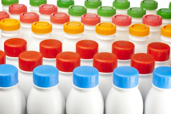 Parlak kapakları olan süt ve süt ürünleri şişeleri — Stok fotoğraf