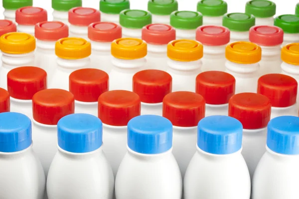 Dairy products bottles with bright covers — Stock Photo, Image