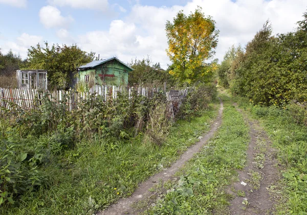 La casa gettata di legno e la strada sterrata in aree rurali — Foto Stock