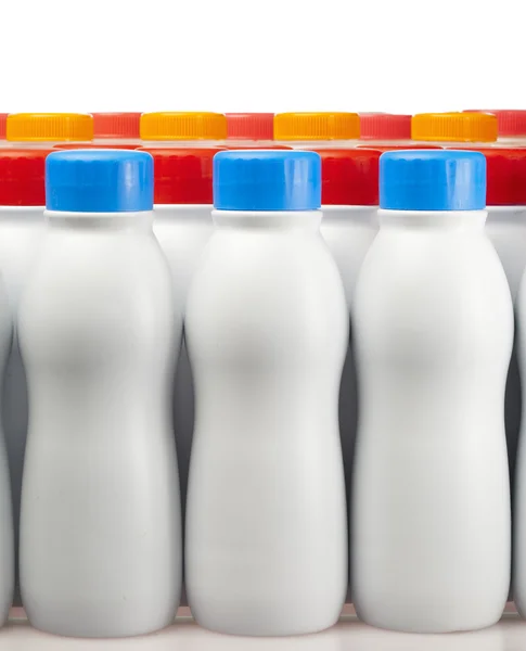 Dairy products bottles with bright covers — Stock Photo, Image