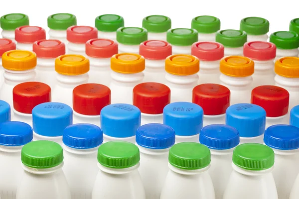 Dairy products bottles with bright covers — Stock Photo, Image