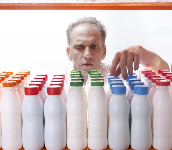 The man selects dairy products in the shop — Stock Photo, Image