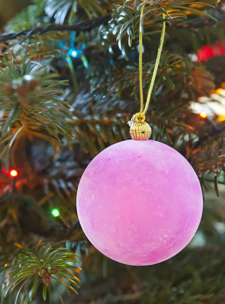 Rosafarbene Neujahrskugeln auf einem Ast eines Weihnachtsbaums — Stockfoto