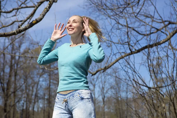 The happy young woman in bright clothes jumps in spring park — Stock Photo, Image