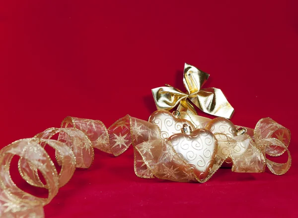 Decoraciones navideñas doradas sobre un fondo rojo —  Fotos de Stock