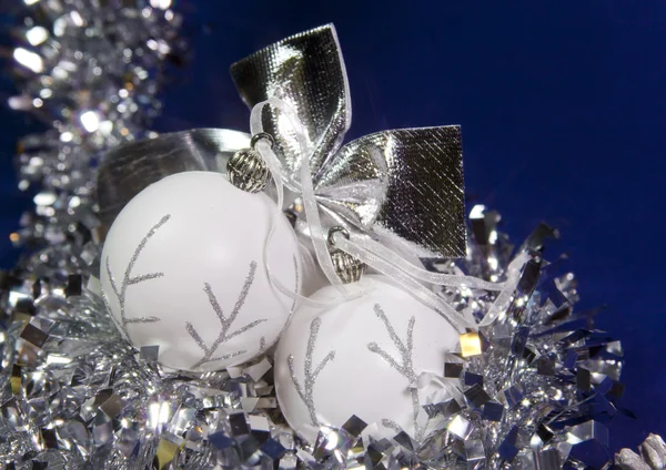 Белые новогодние шары и мишура на синей спинке — стоковое фото