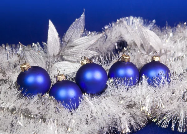 Blue New Year's balls and tinsel on a blue background — Stock Photo, Image
