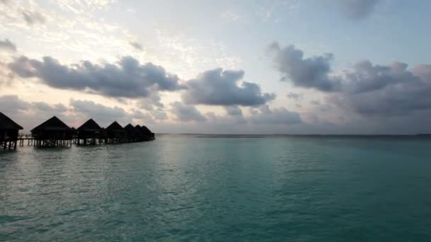 Lodges over water bij de zonsondergang tijd. Maldiven — Stockvideo