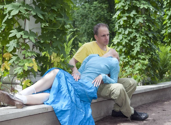 Heureux homme et la femme assis sur un banc dans le parc en été — Photo
