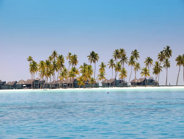 Γλώσσα της άμμου με φοίνικες και ξύλινα σπίτια προς τη θάλασσα, Μαλδίβες — Φωτογραφία Αρχείου