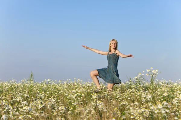 Счастливая молодая женщина в поле ромашки — стоковое фото