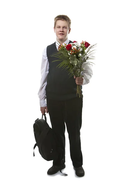 O aluno das classes seniores em um uniforme escolar com um buquê de flor — Fotografia de Stock