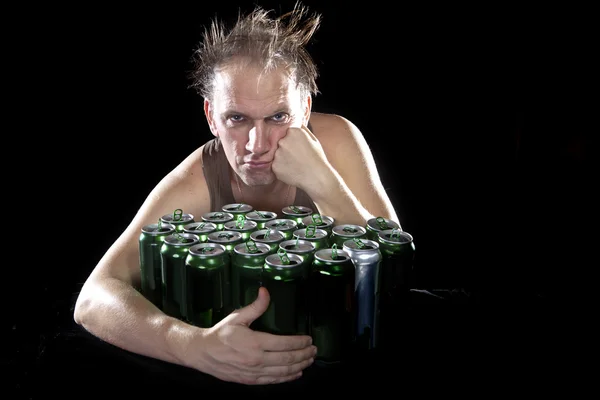 Hangover.The hombre borracho y es un montón de latas de cerveza vacías — Foto de Stock