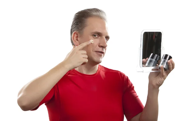 適用クリームは顔の皮膚の世話をする中年の男性 — ストック写真