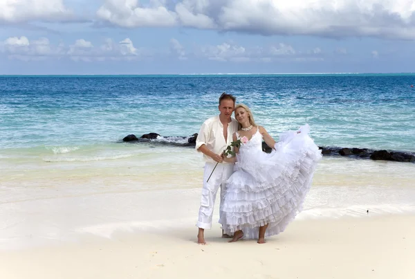 The groom and the bride on the tropical beach. — Stock Photo, Image