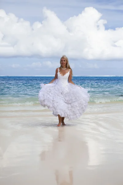 Schöne Frau im Brautkleid auf Sand am Rande des Meeres — Stockfoto