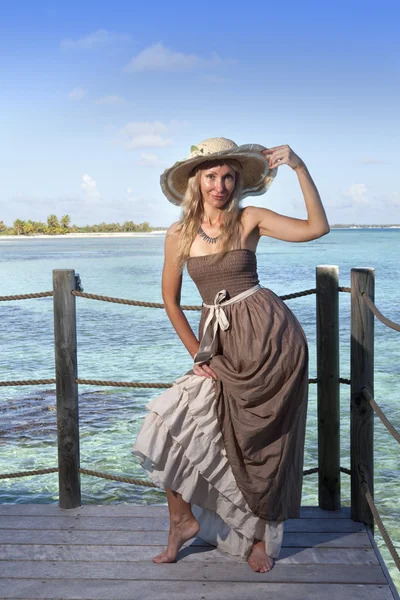 Schöne Frau in einem langen Kleid auf einer Holzplattform über dem Meer — Stockfoto