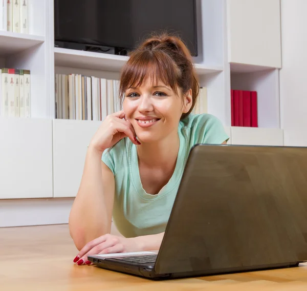 Femme souriante utilisant un ordinateur portable à la maison — Photo