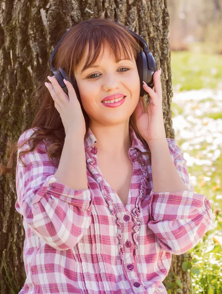 Kvinne lytter til musikk utendørs – stockfoto