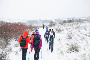 Bir grup yürüyüşçü kış günü yürüyüş yolunda yürüyor..