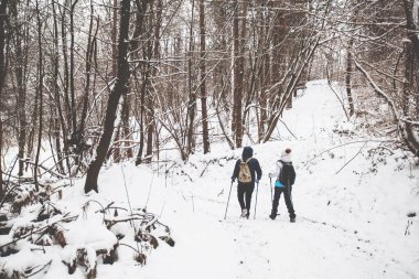 Karlı yolda yürüyüş yapan sırt çantalı yürüyüşçüler. Kış günü birlikte yürüyen aktif insanlar. Arka plan.