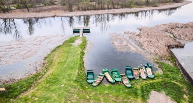 Gölde eski tahta kayıklar. Güzel doğa manzarası. Doğa rezervi. Ağaçların su yüzeyindeki yansıması. Bahar günü. Sırbistan.