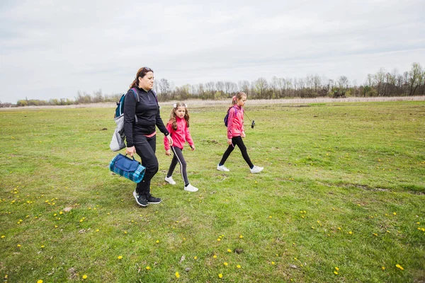 Aile doğada rahatlar, kızları olan anne doğada, ilkbaharda gezer..