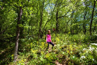 Portrait of adorable hiking little girl on spring day in forest.