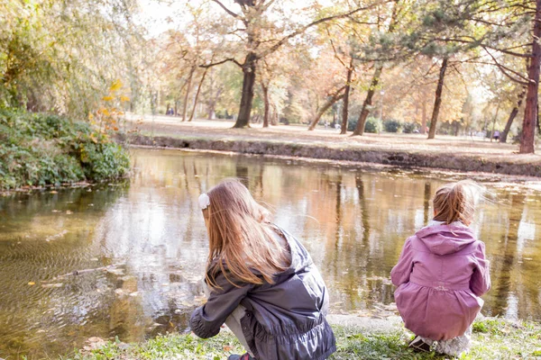 Duas Meninas Brincando Parque Perto Lago Reflexão Árvores Água Outono — Fotografia de Stock