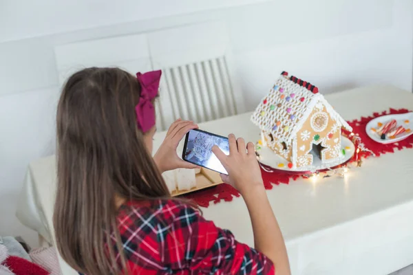 Yaratıcı Küçük Kızlar Evdeki Zencefilli Kurabiye Evinin Akıllı Telefonuyla Fotoğraf — Stok fotoğraf