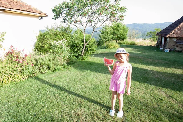 여름날 뜰에서 수박을 미소짓는 소녀의 — 스톡 사진