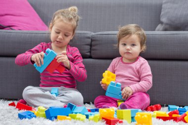 Küçük kız ve birlikte oynayan bebek