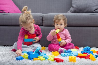 Küçük kız ve birlikte oynayan bebek