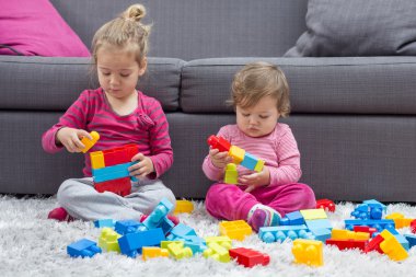 Küçük kız ve birlikte oynayan bebek