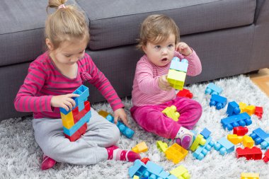Küçük kız ve birlikte oynayan bebek