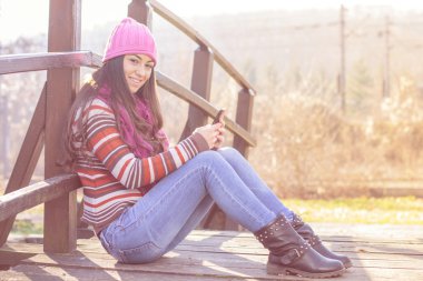 cep telefonu ile gülümseyen kız