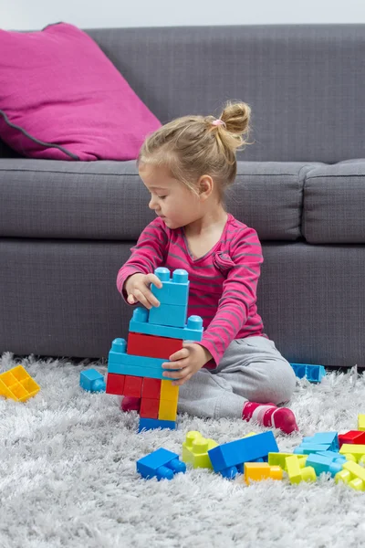 Kleines Mädchen spielt mit Blöcken — Stockfoto